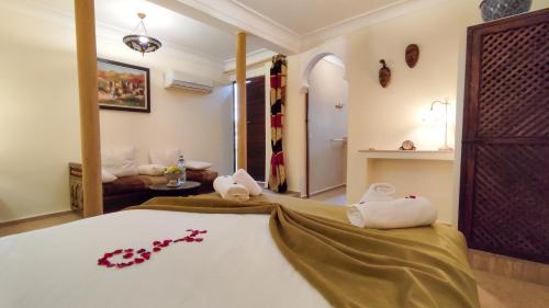 a bedroom with a bed and a living room at RIAD DAR En-Nawat in Marrakech