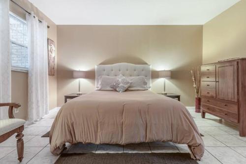 a bedroom with a bed and two tables and a dresser at Glendale Getaway Prime Brandon location in Brandon