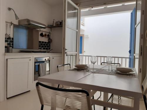 a kitchen with a table and chairs and a window at App ALEX, Estoril Beach - Step away from the sea ( Free Wifi) in Sal Rei