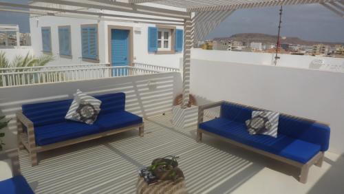a balcony with two blue benches on a house at App ALEX, Estoril Beach - Step away from the sea ( Free Wifi) in Sal Rei