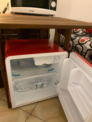 a small refrigerator with water bottles inside of it at Backpackers House in Bologna