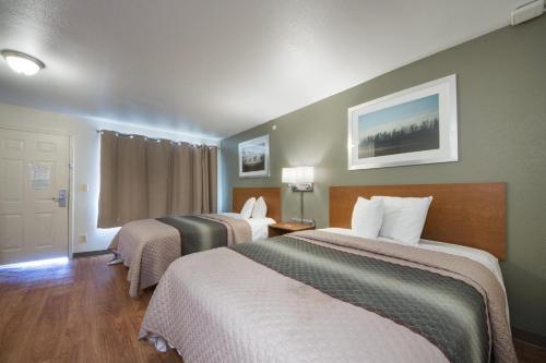 um quarto de hotel com duas camas e uma janela em HomeTowne Studios by Red Roof Dallas - Irving em Irving