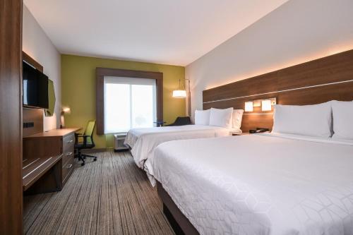 um quarto de hotel com duas camas e uma televisão de ecrã plano em Holiday Inn Express Charlotte Southeast - Matthews, an IHG Hotel em Charlotte