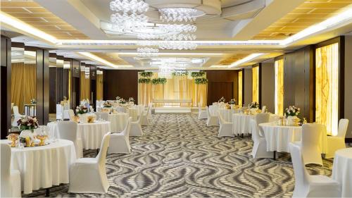 un salón de banquetes con mesas blancas y sillas blancas en Holiday Inn Yanbu, an IHG Hotel, en Yanbu