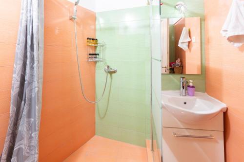 uma casa de banho com um chuveiro e um lavatório. em MATILDA Central Apartment em Egina