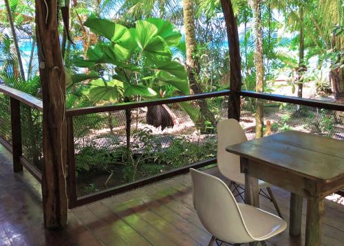 a porch with a wooden table and two chairs at Casa Cayuco Eco-Adventure Lodge in Bocas del Toro