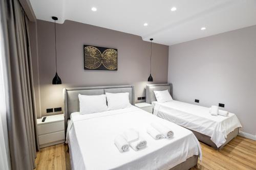 a bedroom with two beds with white sheets at Paradise Point in Korçë