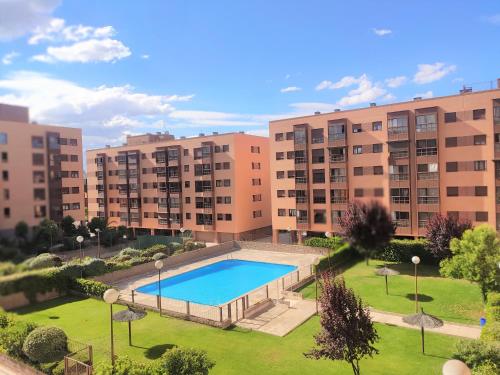 マドリードにあるDeyanira New Suite Madrid Airportの公園内のスイミングプールを併設するアパートメント複合施設