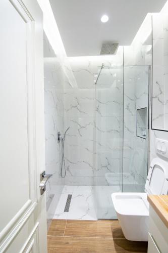 a white bathroom with a shower and a sink at Paradise Point in Korçë