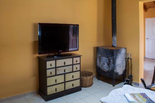 a flat screen tv sitting on a dresser next to a stove at Casa Bodega Antucura in Vista Flores