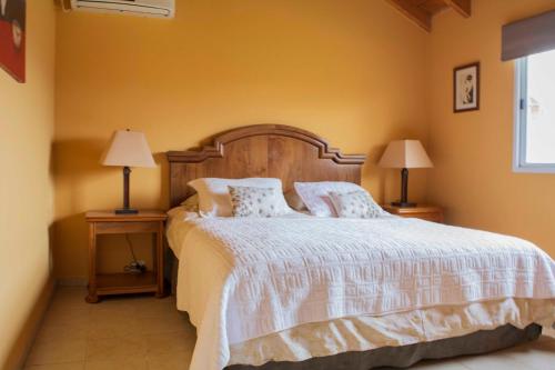 a bedroom with a large bed with two lamps at Casa Bodega Antucura in Vista Flores