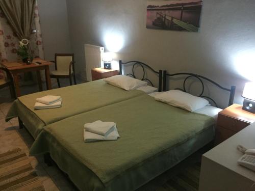 a bedroom with a bed with two towels on it at Hotel Loga in Tycherón