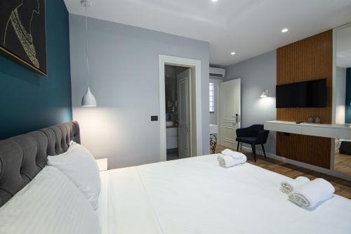 a bedroom with a large white bed and a bathroom at Paradise Point in Korçë
