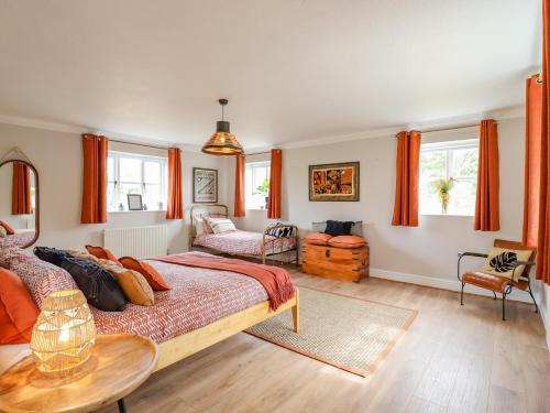 a bedroom with a large bed with orange curtains at Yew Tree Farm in Aylesbury