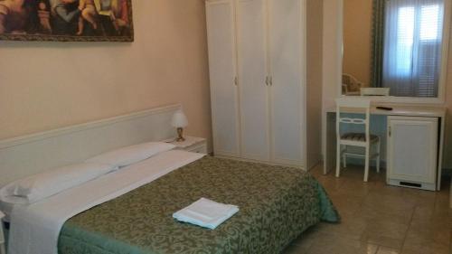 1 dormitorio con cama, mesa y escritorio en B&B Manzoni Resort, en Brindisi