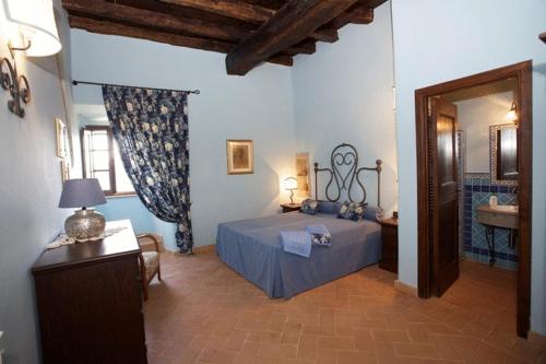 a bedroom with a blue bed and a bathroom at Palazzo Orsini in Mugnano