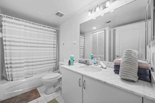 uma casa de banho branca com um lavatório e um WC em PH Luxury 1 Bed 1 Bath • Brickell • Ocean Views em Miami