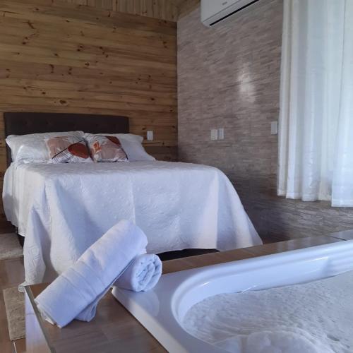 a bedroom with a bed and a bath tub at Portal da alvorada in Praia Grande