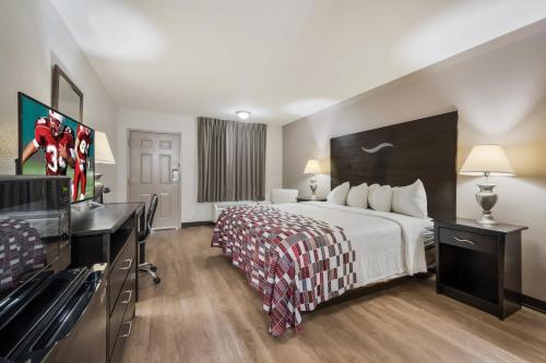 a hotel room with a bed and a desk at Red Roof Inn College Station in College Station