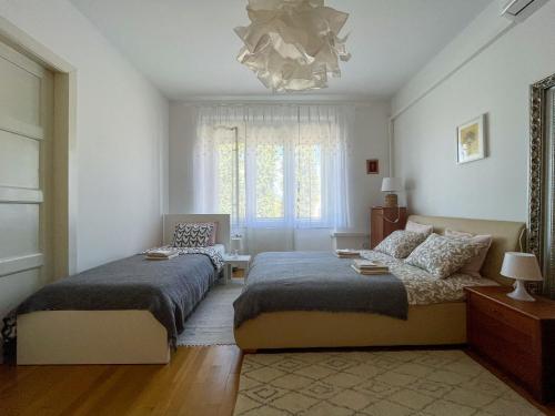 Un dormitorio con dos camas y una lámpara de araña. en Hestia Apartment, en Zagreb