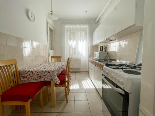 una cocina con una mesa y una estufa horno superior en Hestia Apartment, en Zagreb