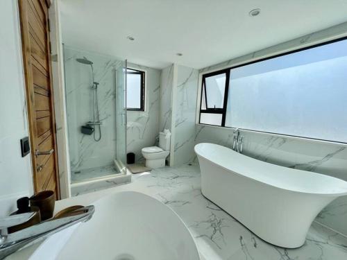 biała łazienka z wanną i umywalką w obiekcie Villa Pereybère White Pearl w mieście Pereybere