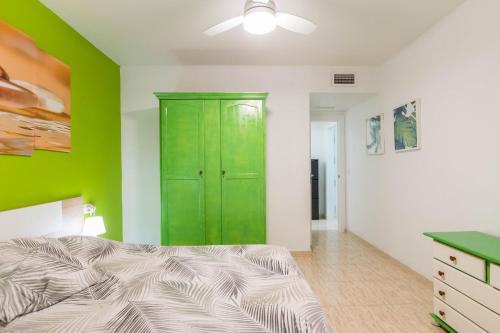 1 dormitorio con armario verde y cama en Apartamento Marqués de Ordoño en Murcia
