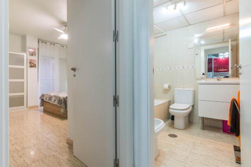 a bathroom with a toilet and a sink and a bed at Apartamento Marqués de Ordoño in Murcia