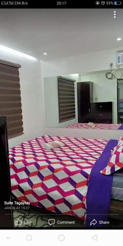 a bedroom with a large bed with a purple and white carpet at Tagaytay Suite 2 in Tagaytay