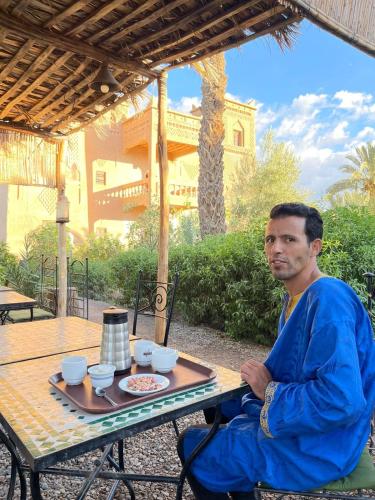 a man sitting at a table with a tray of food at Dar Es Salam in Skoura
