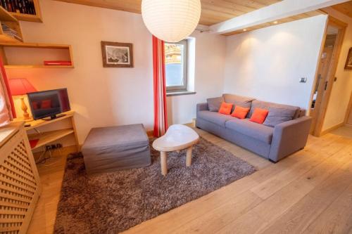a living room with a couch and a tv at Chantemerle 6 in Méribel
