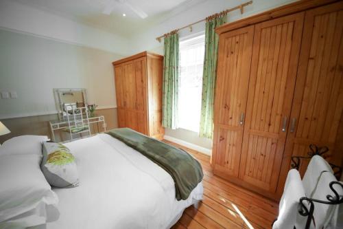 a bedroom with a white bed and a window at CatsWhiskers in Graaff-Reinet