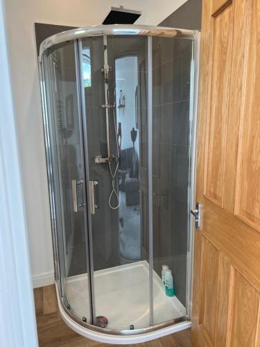 um chuveiro com uma porta de vidro na casa de banho em Beautiful 2 bedroom with patio and amazing views em Hebden Bridge