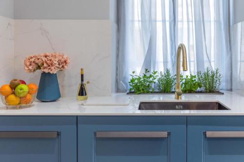 a kitchen counter with a sink and a vase of flowers at New & unique apartment - A 5 minutes ferry to capital city of Valletta in Senglea