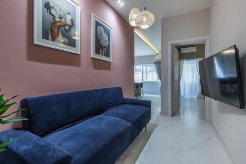 a living room with a blue couch and a tv at New & unique apartment - A 5 minutes ferry to capital city of Valletta in Senglea