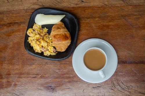 a table with a plate of food and a cup of coffee at Ayenda Flora Jaguar in Ibagué
