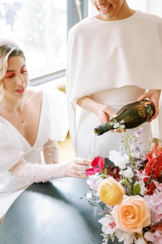 a bride and groom sitting at a table with a bottle of champagne at Virgin Hotels New Orleans in New Orleans