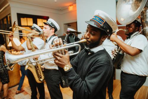 a man playing a trumpet with a band of musicians at Virgin Hotels New Orleans in New Orleans