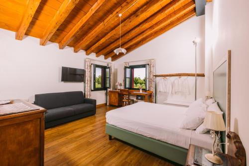 una grande camera da letto con un letto e un divano di Agriturismo Albafiorita a Latisana