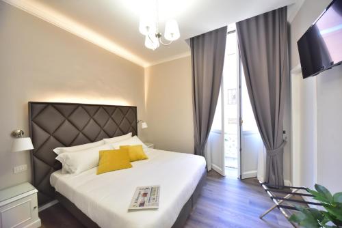 ein Schlafzimmer mit einem großen weißen Bett mit gelben Kissen in der Unterkunft Sacconi Palace Suite Roma in Rom
