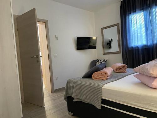 a bedroom with a bed with towels on it at Apartman IVA in Tučepi