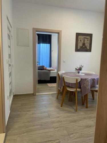 a room with a table and chairs and a bedroom at Apartman IVA in Tučepi