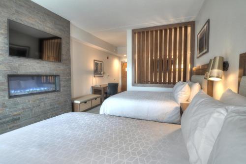 a hotel room with two beds and a tv at Holiday Inn & Suites Pigeon Forge Convention Center by IHG in Pigeon Forge