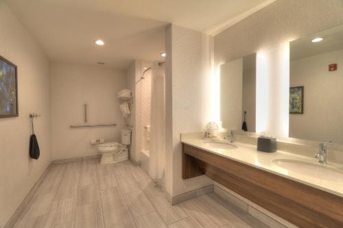 a bathroom with two sinks and a toilet at Holiday Inn & Suites Pigeon Forge Convention Center by IHG in Pigeon Forge