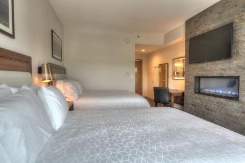 a hotel room with two beds and a flat screen tv at Holiday Inn & Suites Pigeon Forge Convention Center by IHG in Pigeon Forge
