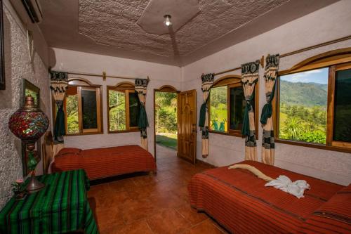 a bedroom with two beds and windows with a view at El Mirador de Tansu in Lanquín