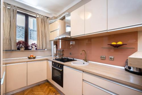 Una cocina con gabinetes blancos y un fregadero. en Casa Lu, en Bucarest