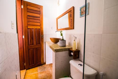a bathroom with a toilet and a sink and a mirror at Pico dos Piratas in Itarema