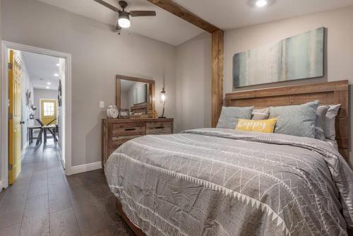 a bedroom with a bed and a dresser and a mirror at Gambino Getaway Shotgun style apt in the heart of Ybor City in Tampa