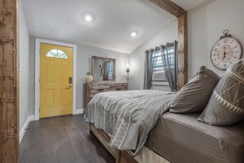 - une chambre avec un lit et une porte jaune dans l'établissement Franks Farmhouse Shotgun style apt in Ybor City, à Tampa